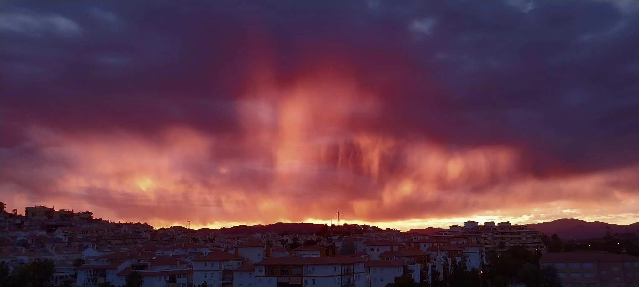 Un espectacular altocúmulo tiñe el cielo de Torre del Mar de rojo y deja imágenes impresionantes